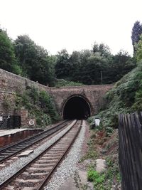 Railroad tracks amidst trees against clear sky