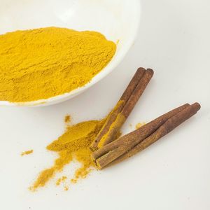 High angle view of cinnamon and turmeric against white background