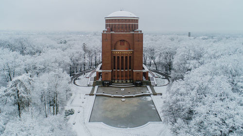 Built structure on snow covered land against sky