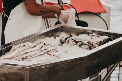 Man holding fish for sale at market