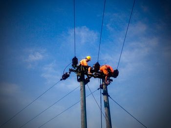 Low angle view of power lines against blue sky