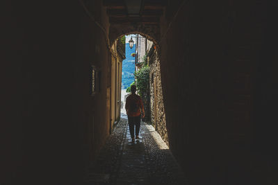 Rear view of man walking in tunnel