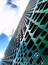 Low angle view of modern building against cloudy sky