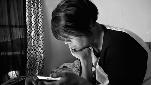 Woman looking at camera while sitting on table at home