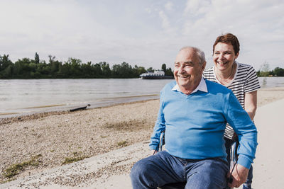 Woman pushing her old father sitting on wheeled walker