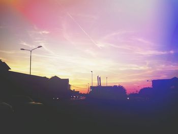 Silhouette buildings against sky at sunset