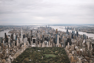 High angle view of city buildings against cloudy sky