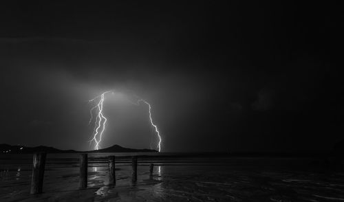 Lightning over sea against sky at night