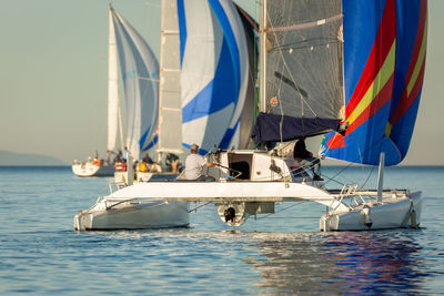 Sailboats sailing in sea against sky