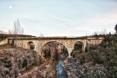 Arch bridge over land against sky