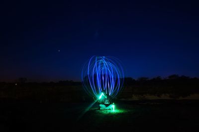 Light painting against clear blue sky at night