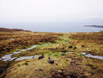 Scenic view of land and sea against sky