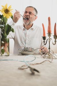 Man eating wires at table
