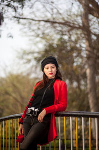 Portrait of young woman standing on footbridge