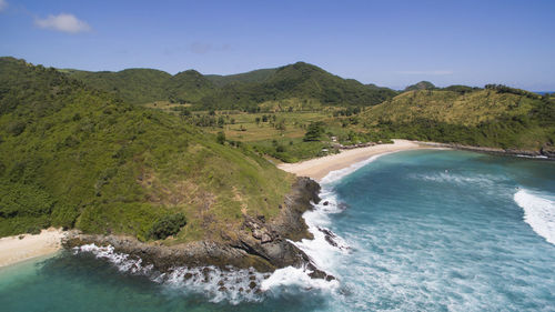 Scenic view of sea and mountains against blue sky