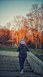 Rear view of woman walking in park during winter