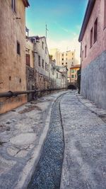 Road amidst buildings against sky