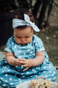 Cute boy looking away while sitting outdoors