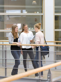 Three university student talking at corridor