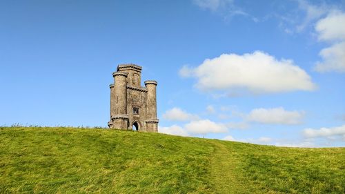 Low angle view of castle on field against sky