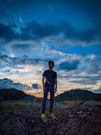 Man standing on field against sky during sunset