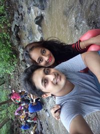 Portrait of brother and sister against stream in forest