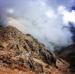 Smoke emitting from volcanic mountain against sky