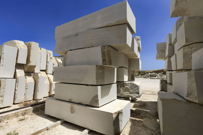 Stack of abandoned building on field against clear blue sky