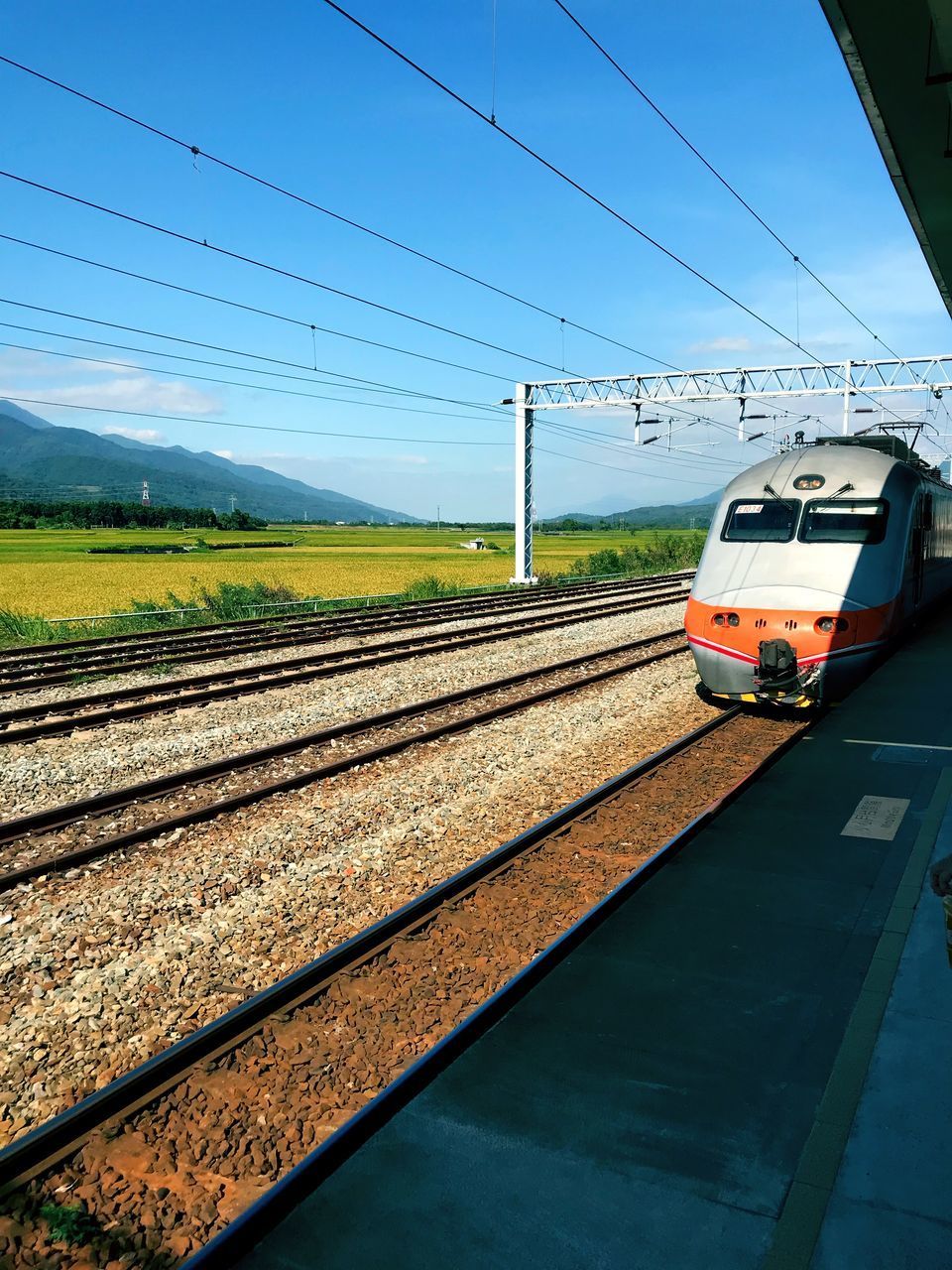 TRAIN ON RAILROAD TRACK AGAINST SKY SEEN THROUGH WINDSHIELD