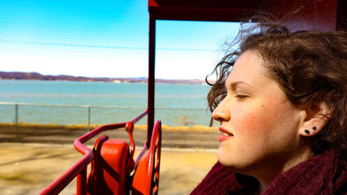 Close-up of woman looking away against lake