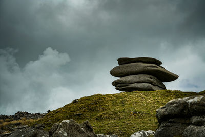 Low angle view of stack on rock against sky