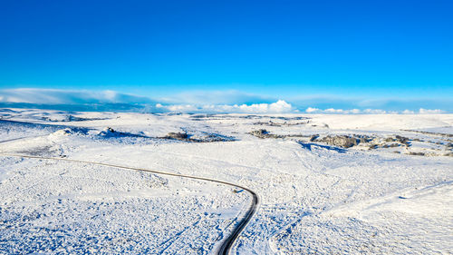 Scenic view of snowcapped mountains against blue sky