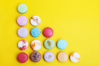 Directly above shot of multi colored candies against yellow background