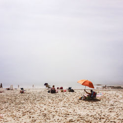 People at beach against sky