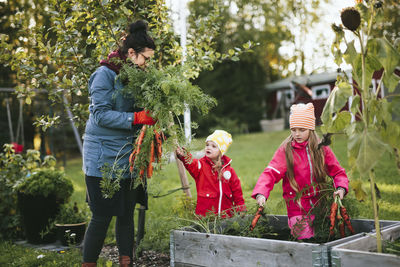 Mother with daughters on vegetable patch