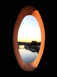 Scenic view of river against clear sky seen through arch