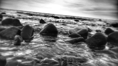 Rocks in sea against sky