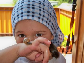 Close-up portrait of girl with snail