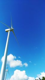 Low angle view of windmill against blue sky