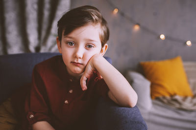 Portrait of boy sitting at home