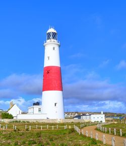 Lighthouse by sea against sky