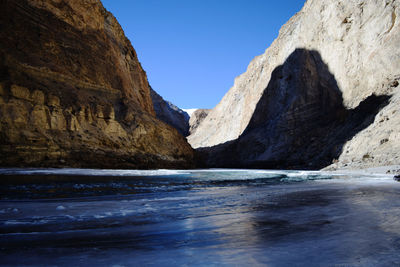 Scenic view of frozen zanskar river against rocky mountains