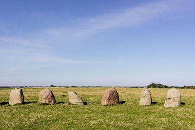 Hay bales on field against clear sky