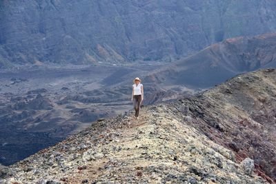 High angle view of female hiker standing on mountain