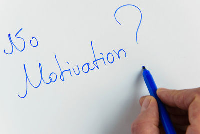 Cropped hand of person writing with felt tip pen on whiteboard