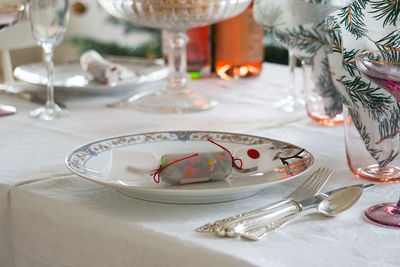 Close-up of table setting with plates and  wine glasses on table
