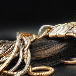 Close-up of pipes and hair against black background