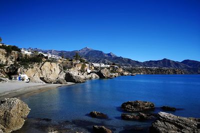 Scenic view of spanish beach, cliffs and rocks against clear blue sky amd sea