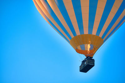 Flying hot air balloon against bright blue sky