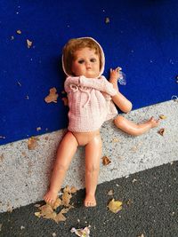 Portrait of cute plastic dismembered doll with two arms on the same side